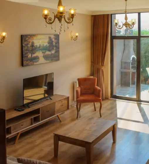 A2 villasının salonu: avize, ahşap mobilyalar ve terasa açılan cam kapı